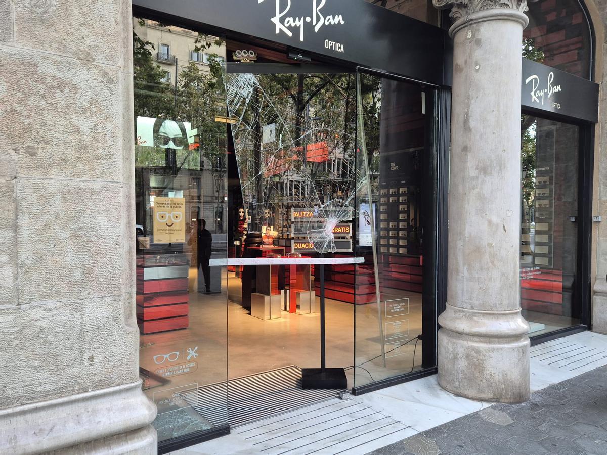 Una tienda asaltada y con el escaparate destrozado en el paseo de Gràcia, en Barcelona.