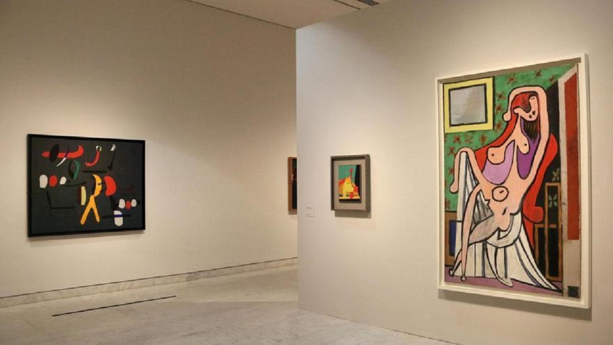 «El gran desnudo en una butaca roja», de Pablo Picasso, dialoga con «Llama en el espacio y mujer desnuda», de Joan MIró en la exposición.