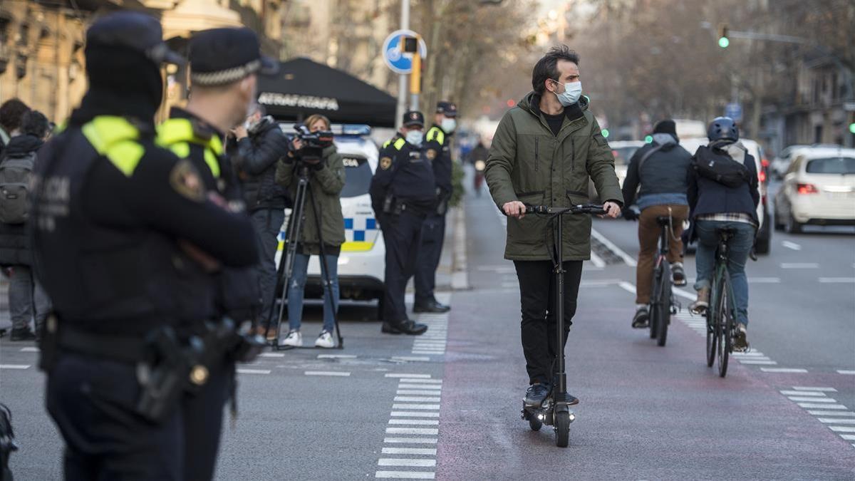 Barcelona 19 01 2021  Barcelona  La Guardia Urbana  en la foto en el cruce de las calles de Diputacion con Urgell  inicio hoy a multar a los usuarios de patinetes que no lleven casco y aquellos que lleven a sus hijos de  paquete   Fotografia de Jordi Cotrina