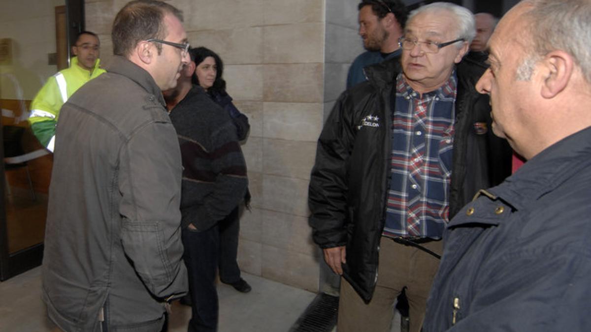 El alcalde de Rasquera, Bernat Pellisa (izquierda), habla con unos vecinos antes de un pleno municipal, el pasado 15 de marzo.