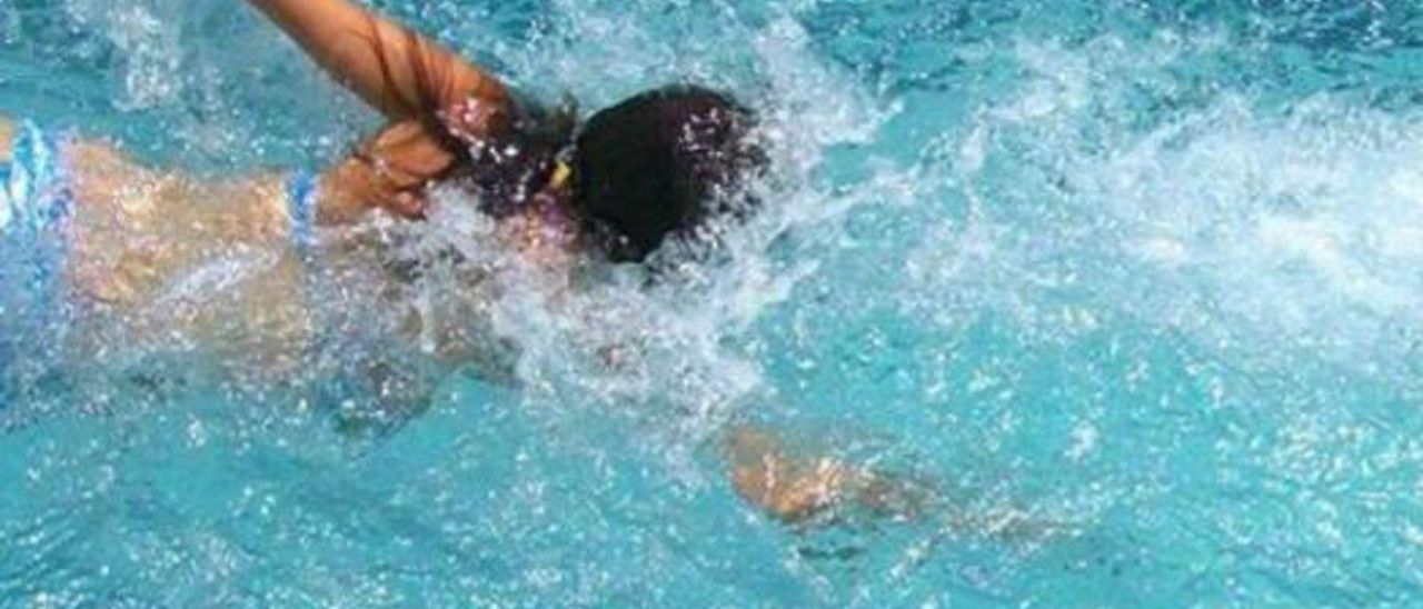 Una joven nadando en una piscina.