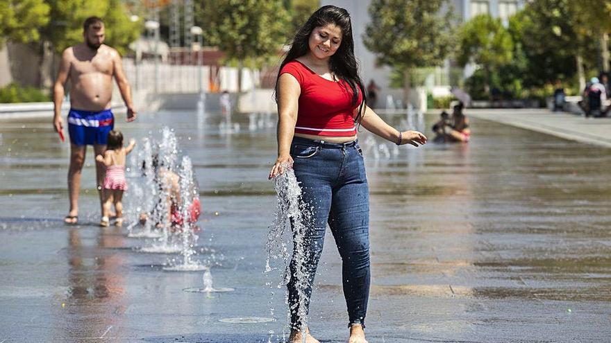 Tres personas se refrescan ayer en una imagen tomada en el Parque Central de València.