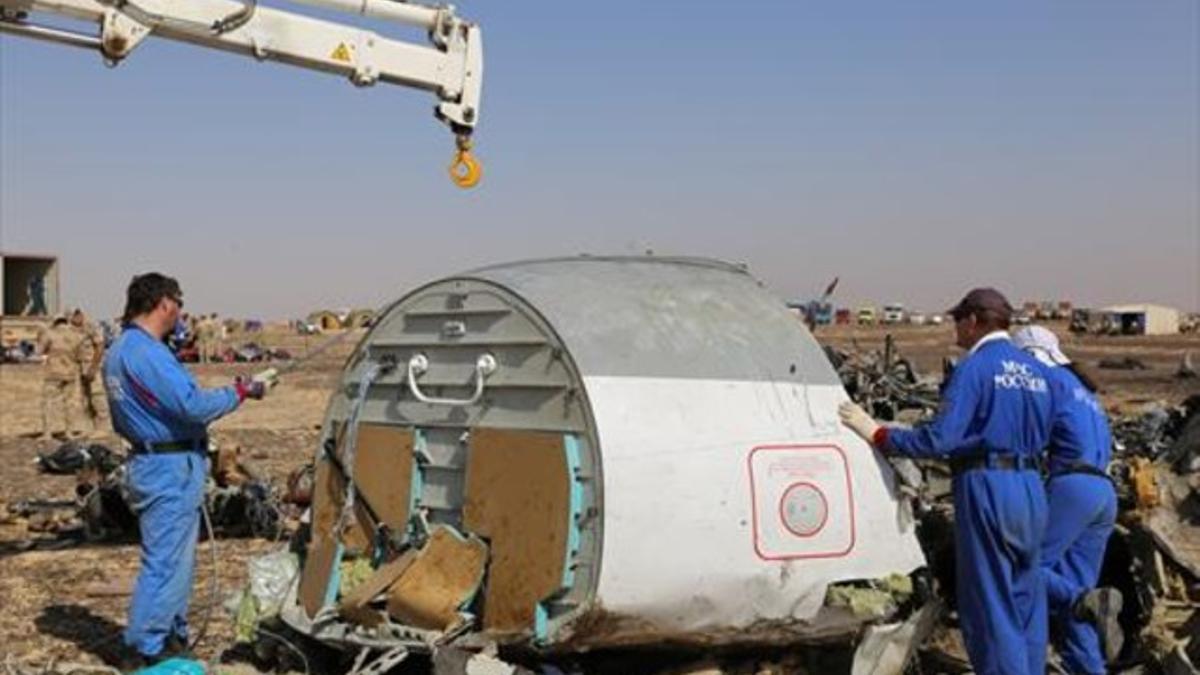 Personal ruso inspecciona los restos del avión siniestrado, el lunes.