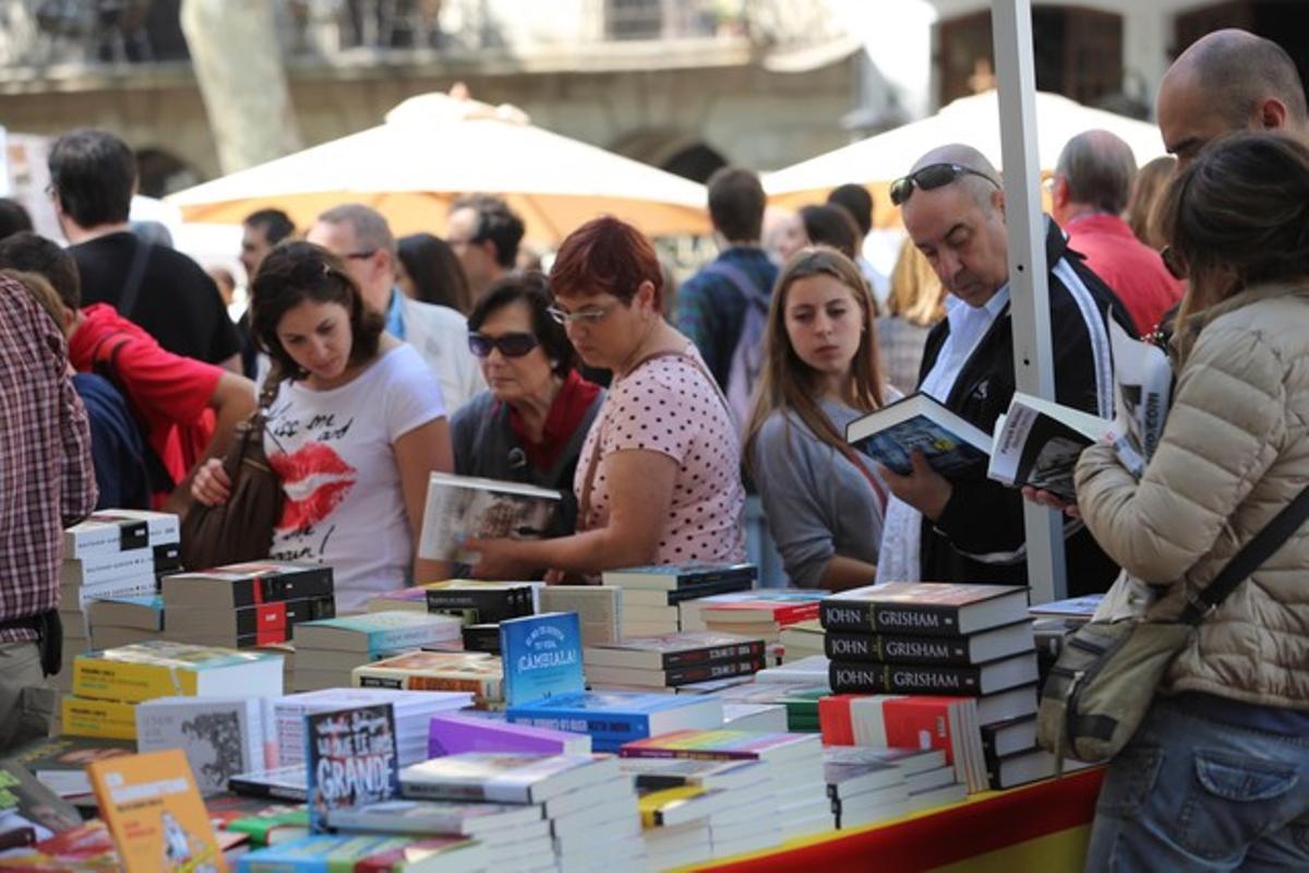 Els lectors busquen llibres en algunes de les parades que inunden Barcelona la diada de Sant Jordi.