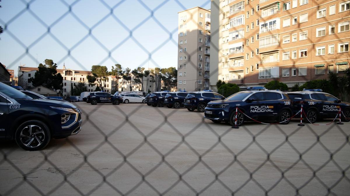 Varios coches de la Policía Nacional estacionados en un solar del paseo María Agustín.