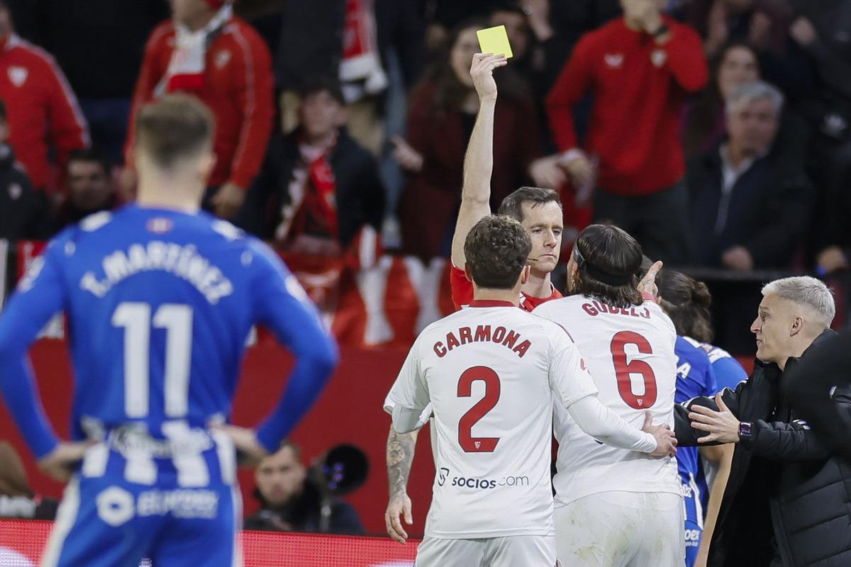 El árbitro Iosu Galech Apezteguía saca amarilla a Nemanja Gudelj durante el partido de la jornada 24 de LaLiga que Sevilla FC y Deportivo Alavés disputaron en el estadio Ramón Sánchez-Pizjuán