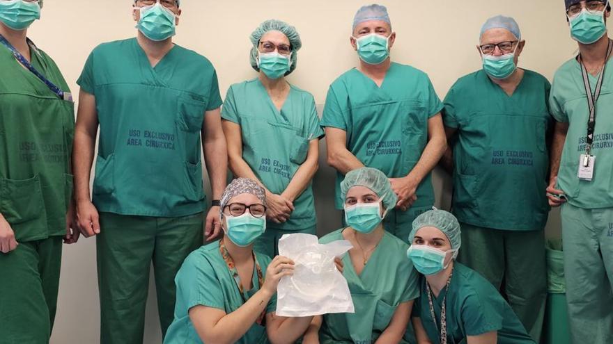 El equipo de profesionales que participó en la cirugía mostrando el dispositivo de succión abdominal empleado en la intervención.   | // FDV
