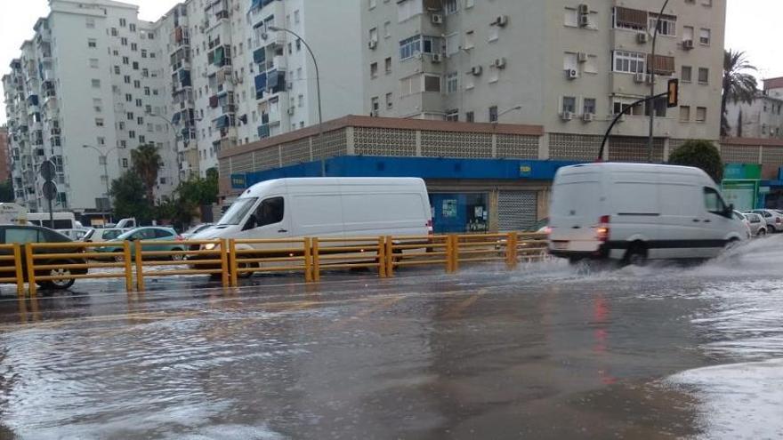 Calzada con agua tras las intensas lluvias en la Carretera de Cádiz, en Málaga capital.