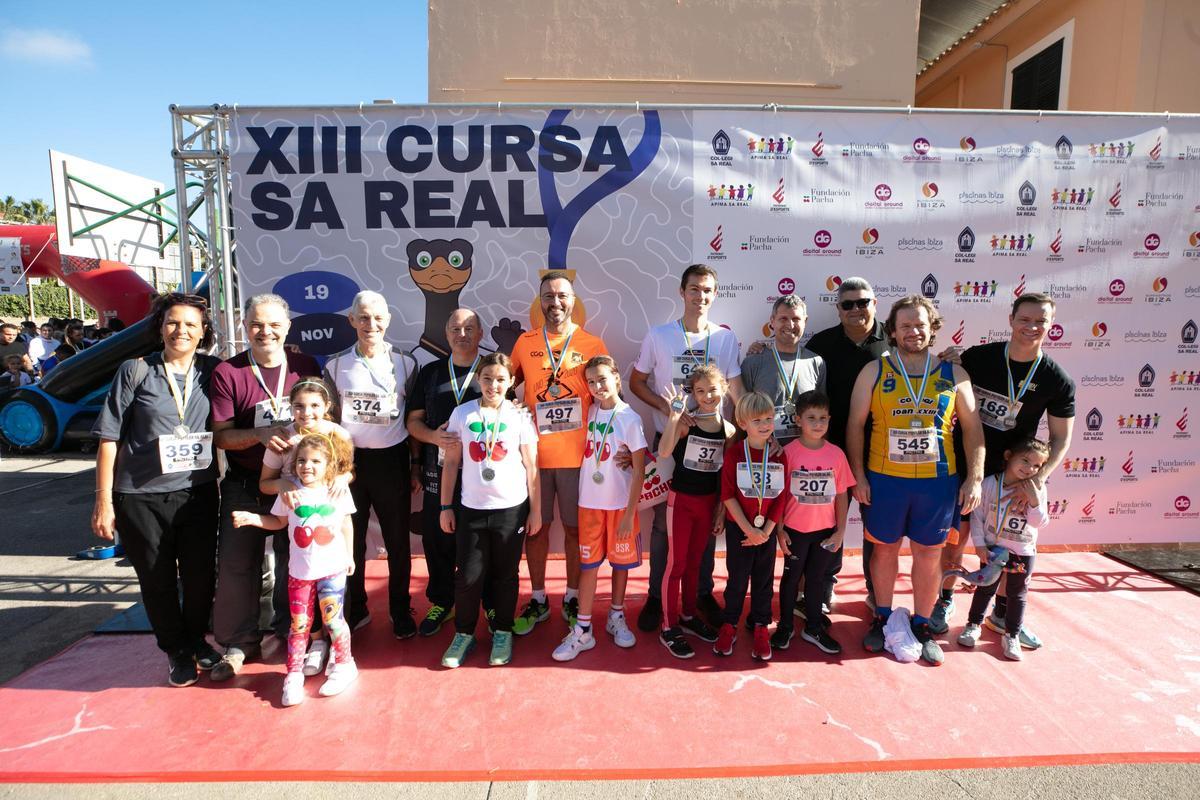 Algunos profesores y antiguos alumnos de Sa Real posan con sus hijos en el 'photocall' de la XIII Cursa Sa Real.