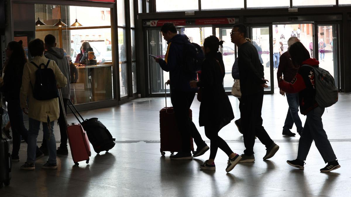 Numerosas personas con maletas salen de viaje e