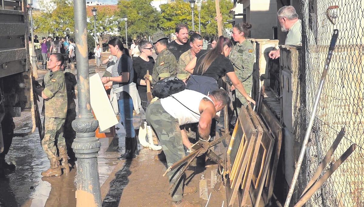 Militares del Ejército de Tierra retirando enseres y arrastrando barro en las calles de Paiporta.