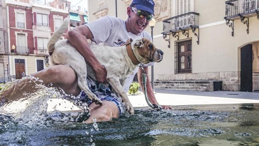 Un vecino se baña en una fuente en Orihuela