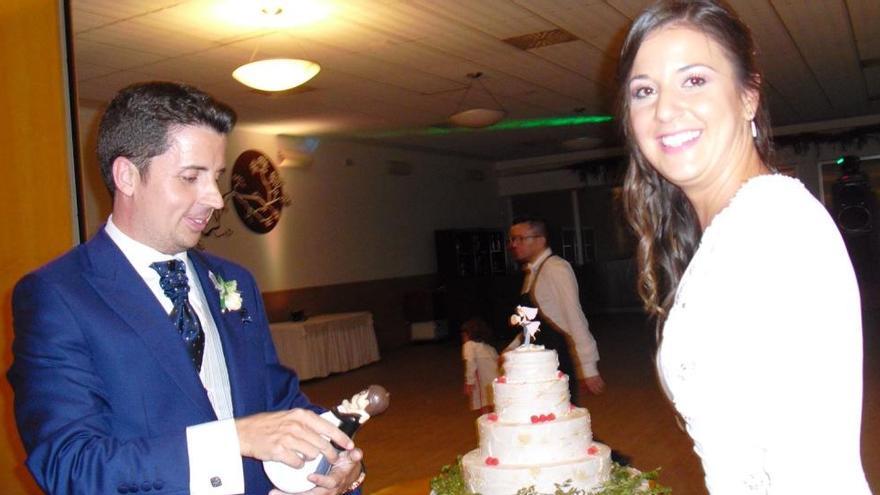 Antonio mira los muñecos de la tarta mientras Maje posa para el fotógrafo el día de su boda.