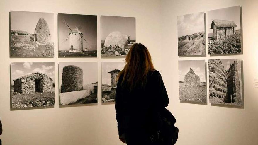 Una mujer observa fotografías expuestas.