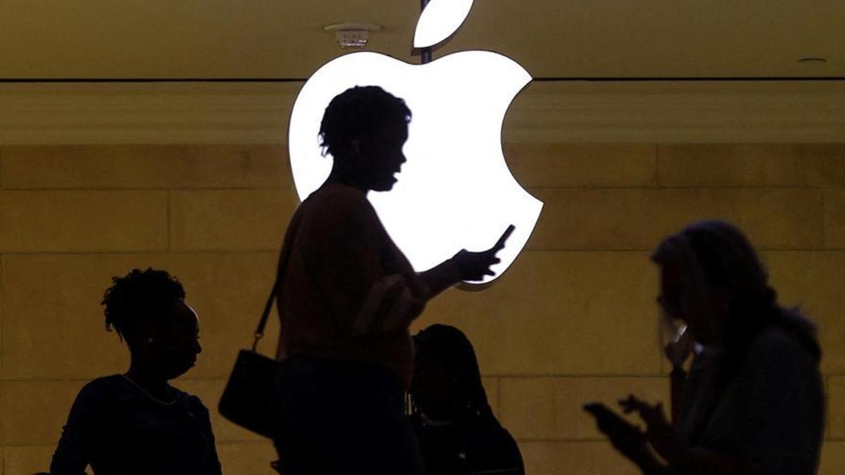 Una mujer ante el logo de Apple.