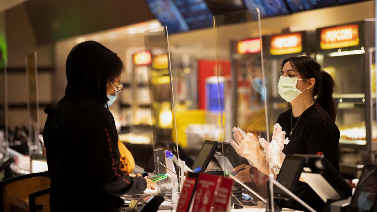 Una mujer compra una entrada de cine en California.