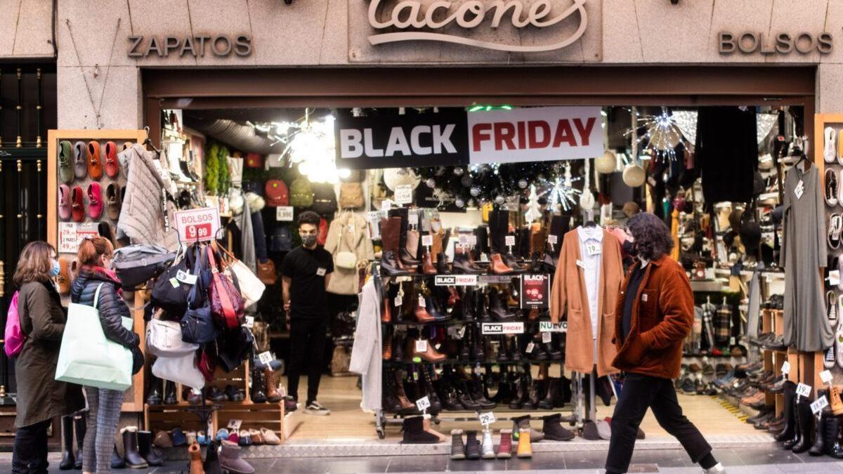 Clientes caminan frente a un establecimiento con rebajas por el Black Friday.