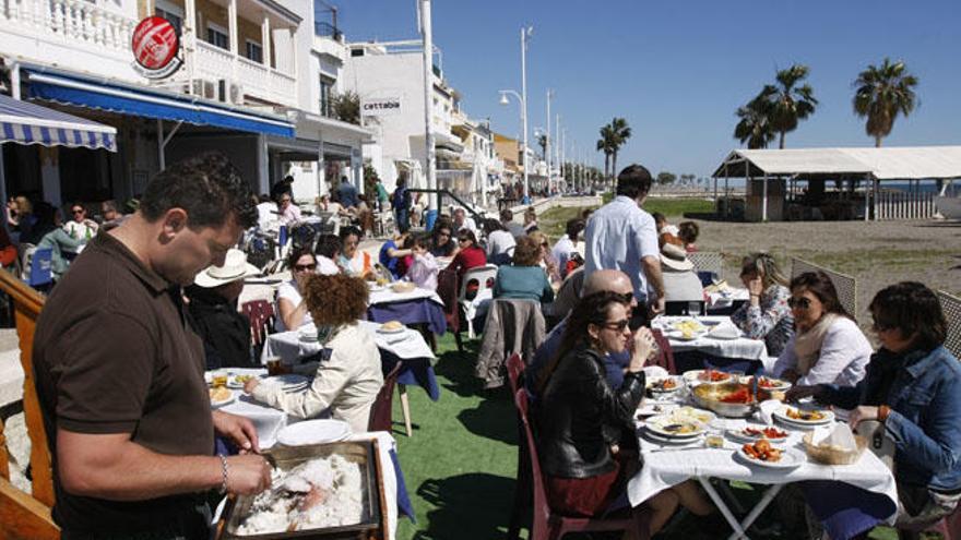 Unos clientes comen en un establecimiento junto a las playas de Málaga.