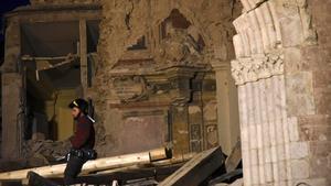  Un bombero trata de recuperar objetos de la basílica de San Benedetto, en Norcia, dañada por los terremotos.
