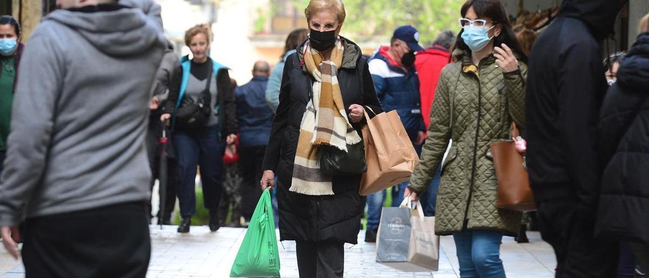 Ciudadanos con bolsas de comercios de Plasencia, que han detectado una bajada de hurtos.