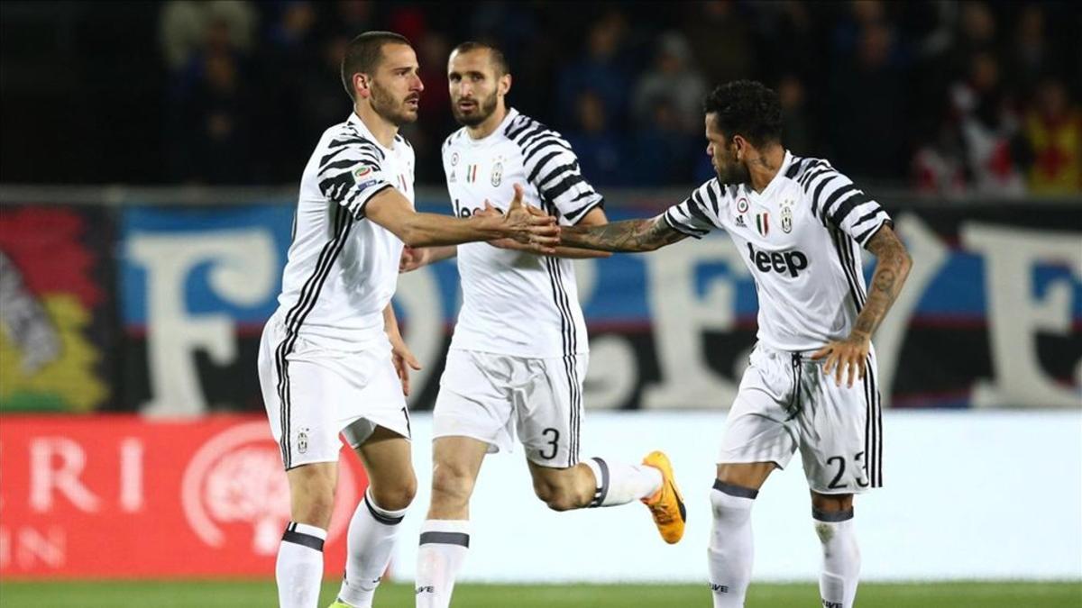 Bonucci y Alves se dan la mano durante un partido de la pasada temporada