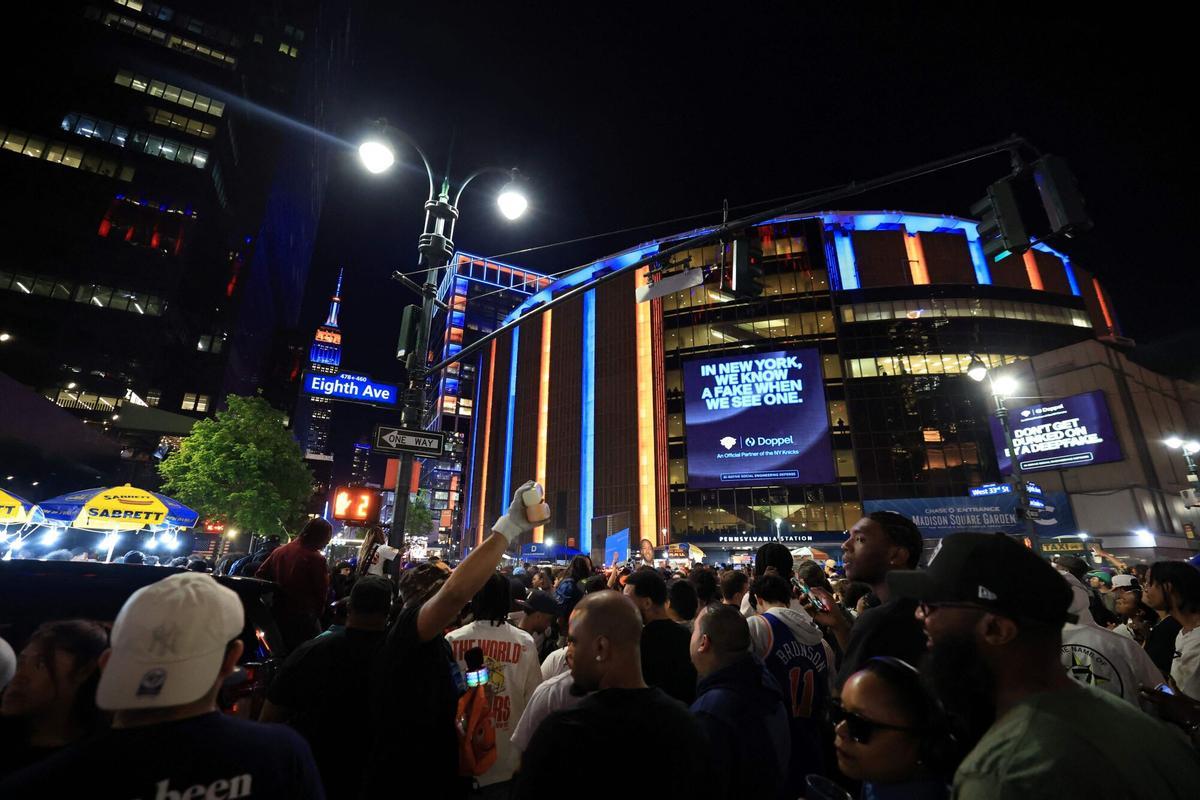 (FILES) Basketball fans gather outside Madison Square Garden during Game 1 of the NBA Finals between the New York Knicks and the San Antonio Spurs, in New York City, on June 3, 2026. As New York prepares to host the World Cup, the city is instead awash in Knicks blue and orange, reflecting a deep love for the gritty, unifying team chasing a historic NBA Finals victory. The Knicks took a commanding 2-0 lead on June 5 in the best of seven series against the San Antonio Spurs, and now the action shifts to the Big Apple for games three and four. (Photo by Timothy A. CLARY / AFP). To go with AFP story by Raphael HERMANO "In the Knicks, New Yorkers see their own resilience reflected"