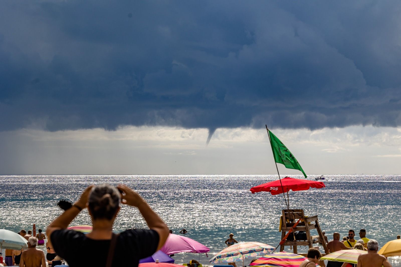 Los bañistas permanecen en las playas de Benidorm pese a la amenaza de lluvias