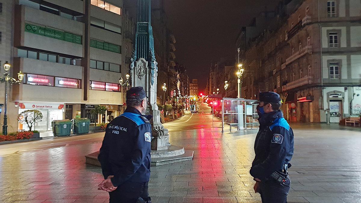 Dos policías patrullan el centro de Vigo por la noche.