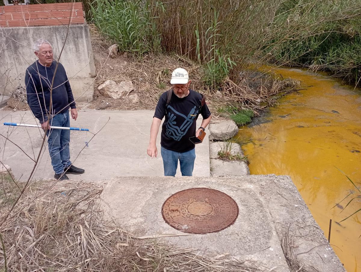 Dos voluntarios de Xúquer Viu junto al barranco Ample de Carcaixent donde detectaron el vertido industrial.