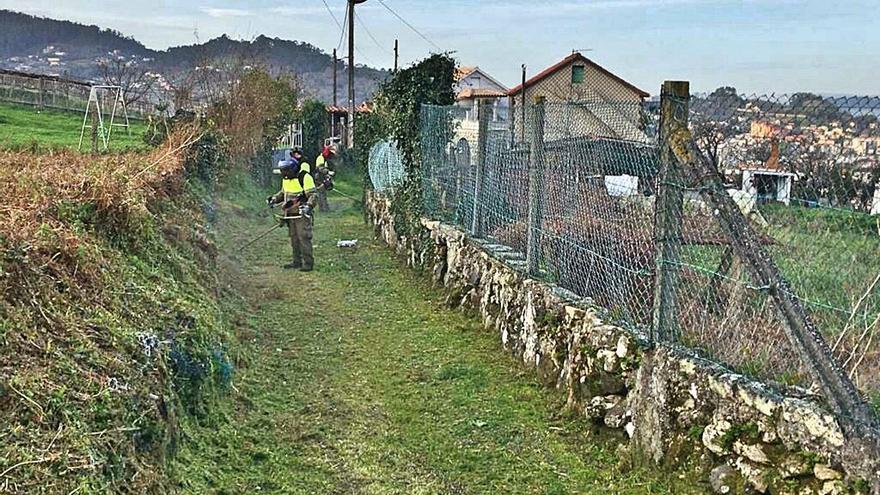 Tareas de desbroce cerca de las casas, en Marín. | // SANTOS ÁLVAREZ