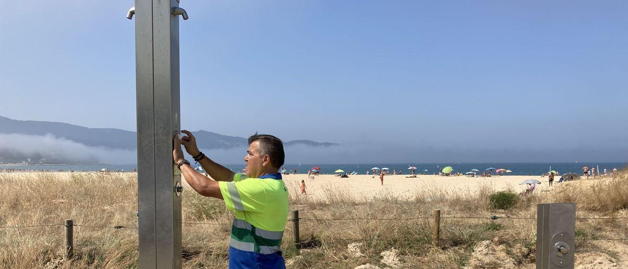 Un operario precintaba ayer una de las duchas de Praia América.