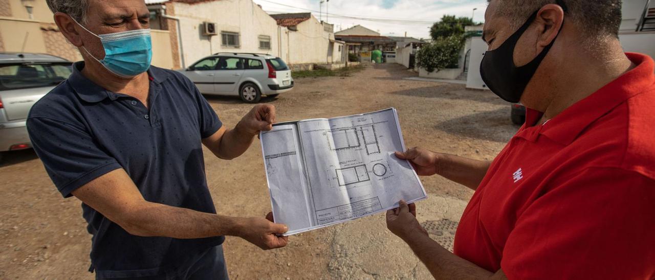 Ricardo Contreras, a la derecha, muestra un plano que le entregó el Ayuntamiento para «encontrar» las fosas sépticas  de Torreta II.