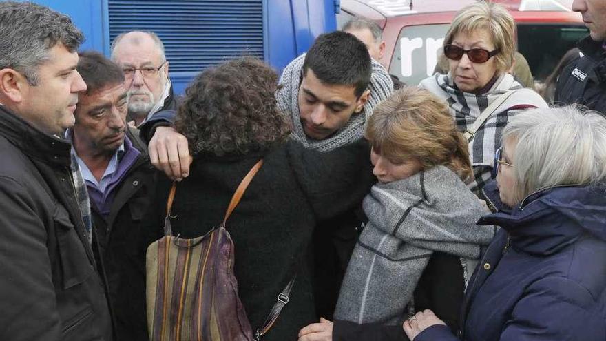 El hermano y la madre de Ana María (centro) recibe el pésame de una vecina, ayer Boqueixón.