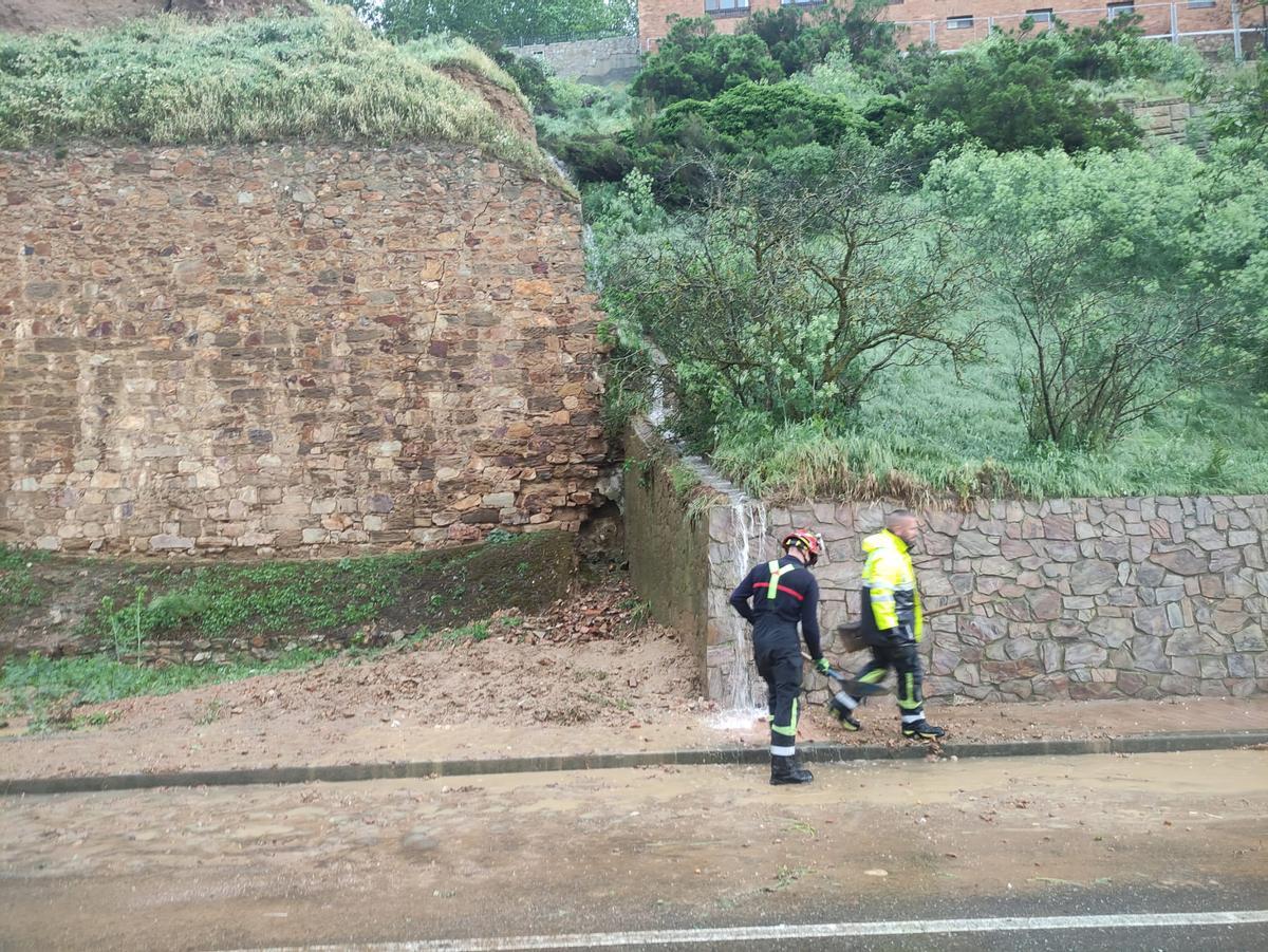 Los bomberos retirando tierra que cubría parte de uno de los carriles del Caracol.