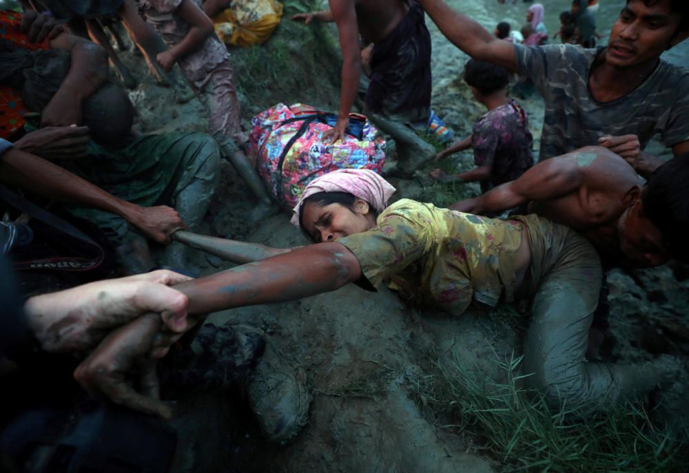 Photographers help a Rohingya refugee to come o...