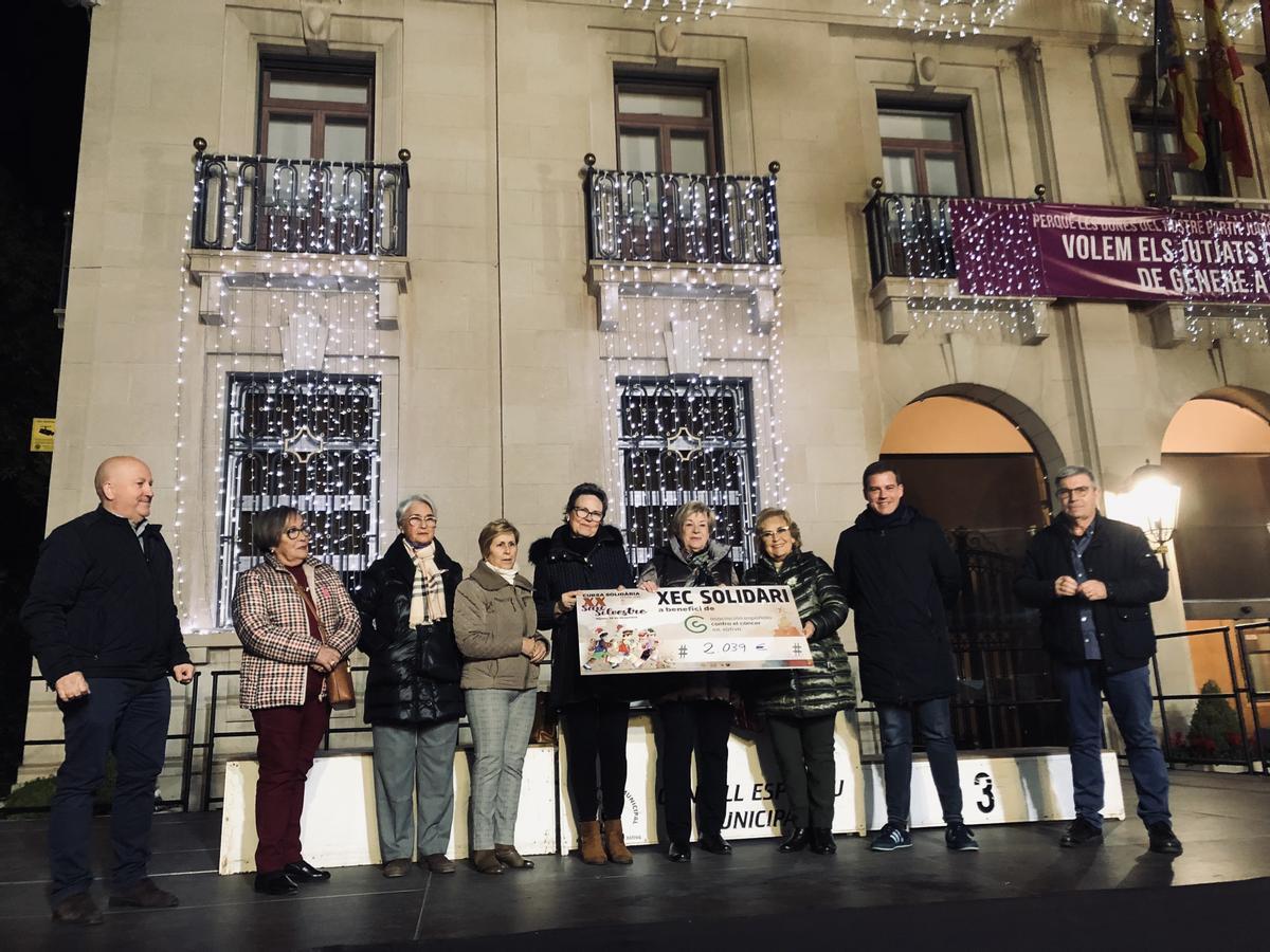 Representantes de la AECC de Xàtiva y el alcalde con el cheque de la recaudación.