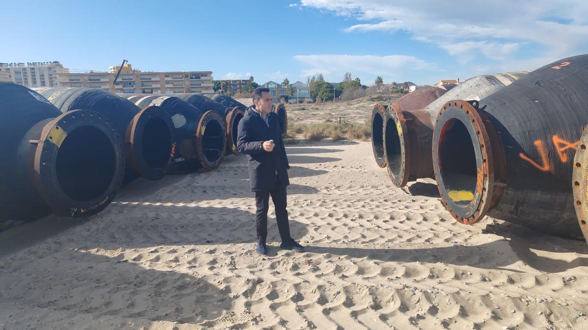 El alcalde de Canet, Pere Antoni, junto a las tuberías que depositarán la arena en las playas del norte de Sagunt.