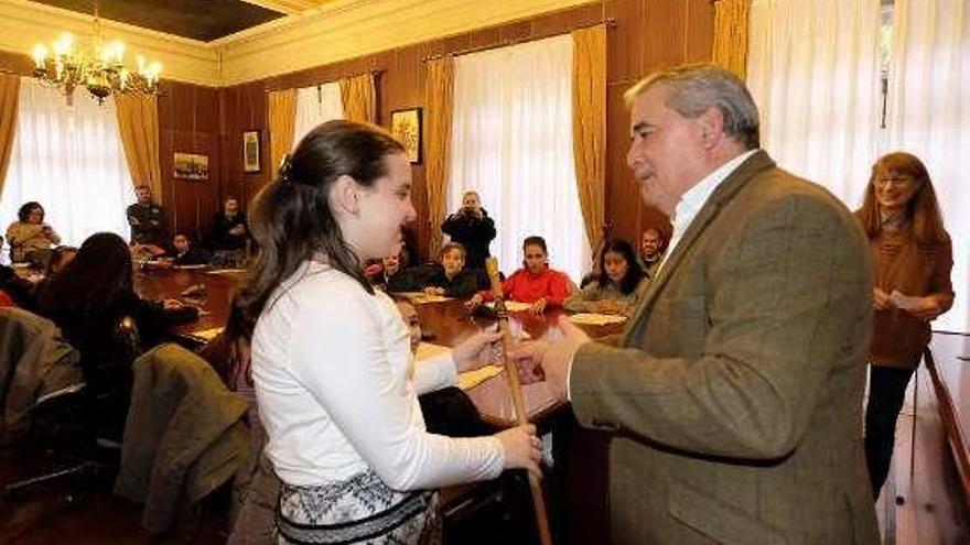 Andrea Argüelles recibe el bastón de Aníbal Vázquez.