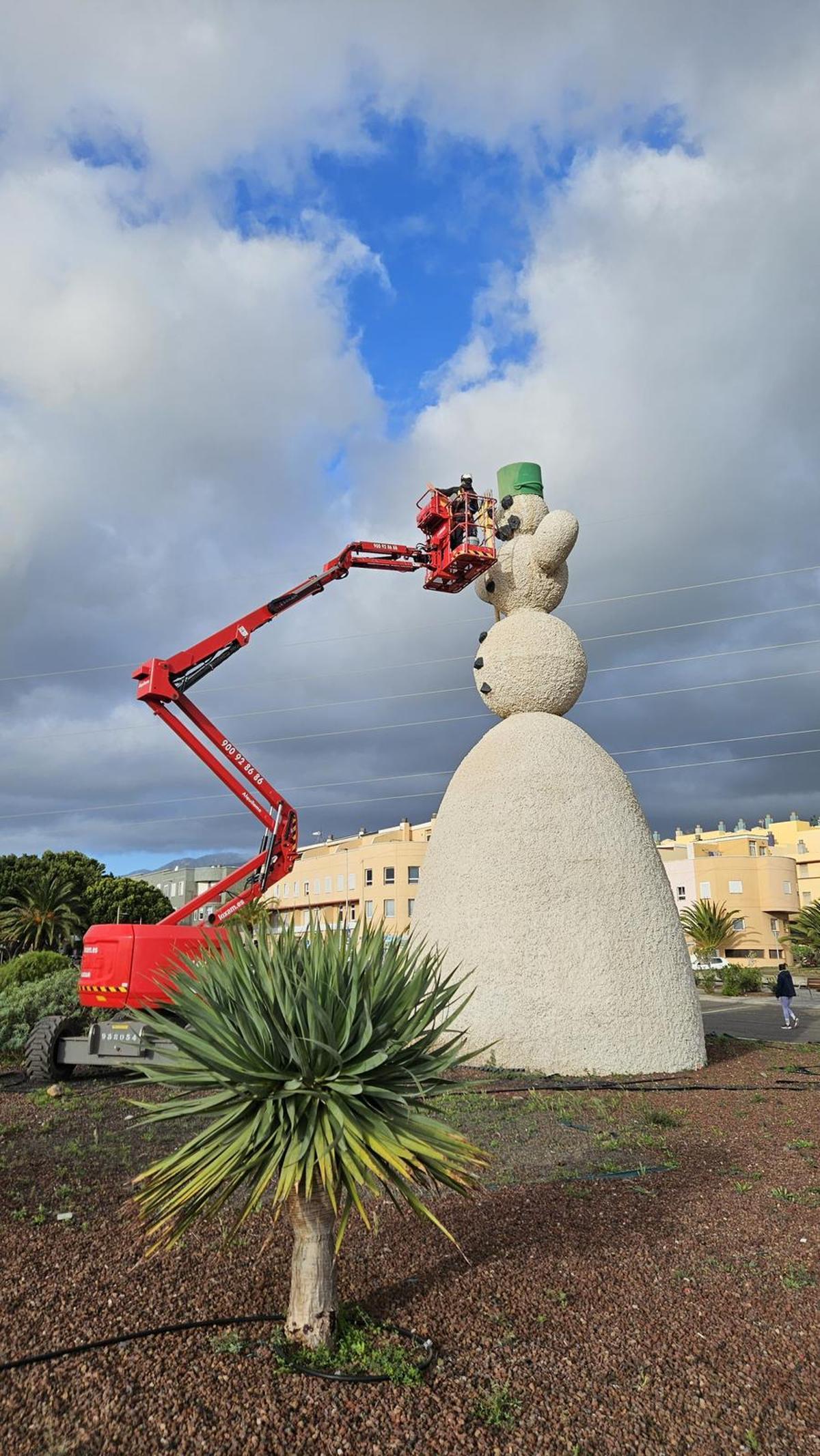 Los técnicos del Ayuntamiento de Santa Cruz de Tenerife colocan la nariz al muñeco de nieve.