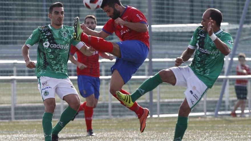 Un jugador del Arenteiro trata de despejar el balón ante la presión de un rival. // Ricardo Grobas