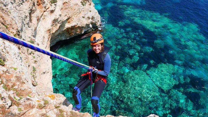 Raquel Fondevila haciendo rapel para visitar una cueva del archipiélago balear con expedicionarios de Explora Mallorca.