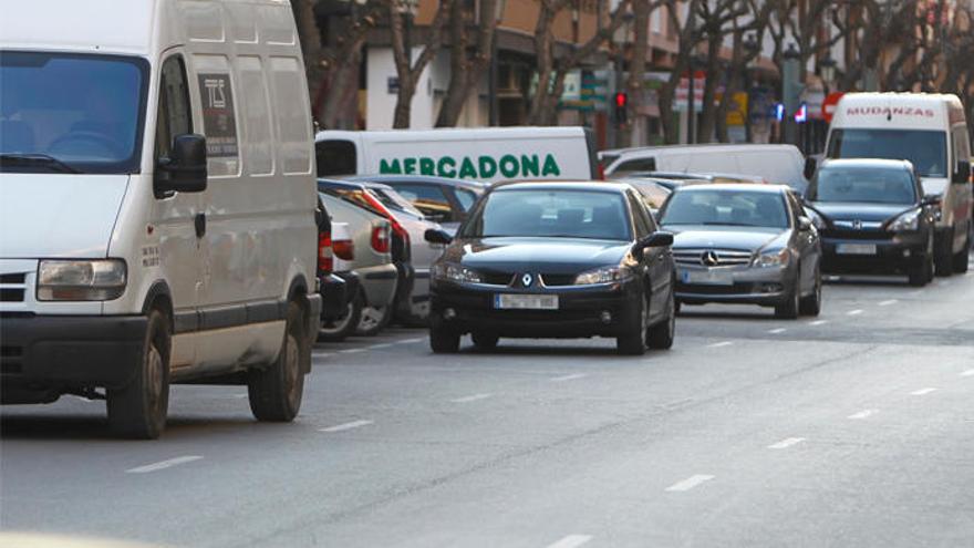 Varios vehículos detenidos en doble fila en Valencia.