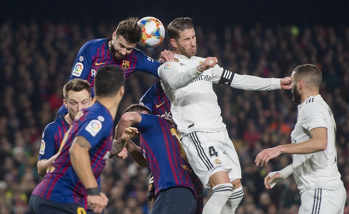 Gerard Piqué despeja un balón ante Sergio Ramos durante el encuentro de ida de las semifinales de la Copa del Rey.