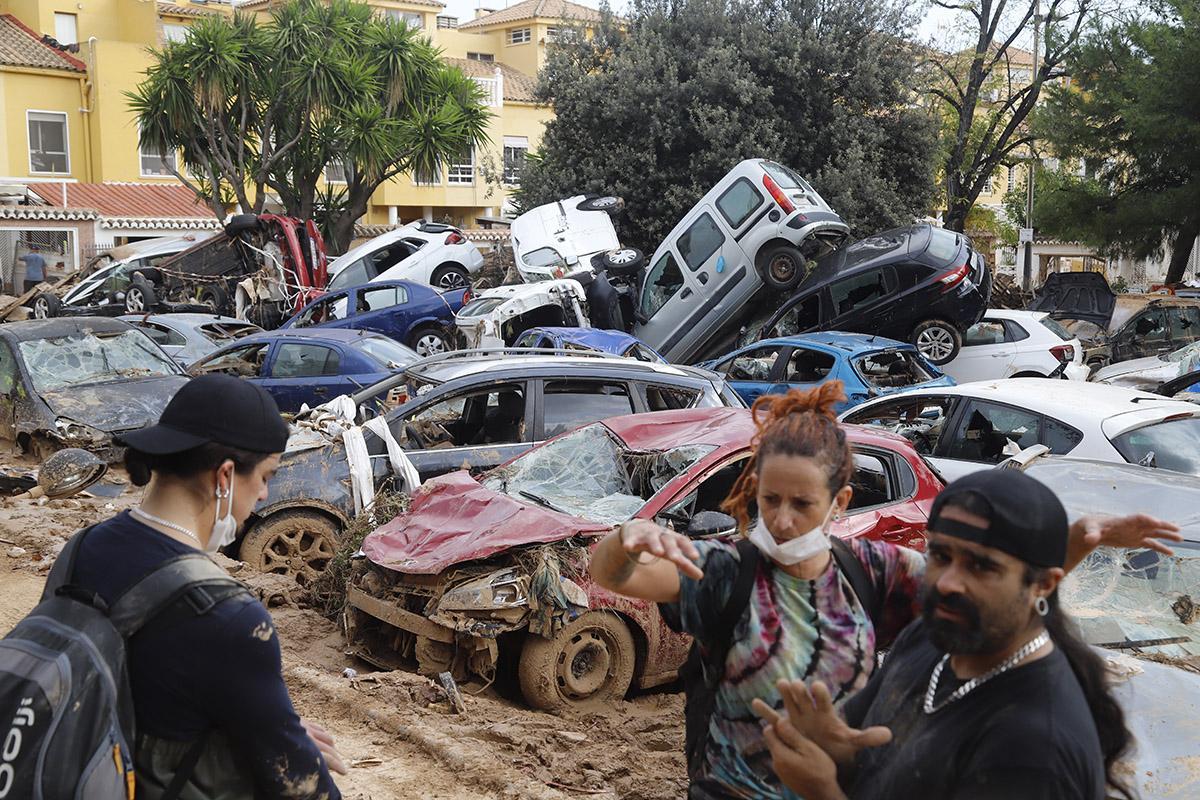 Coches destrozados y apilados en un parque.