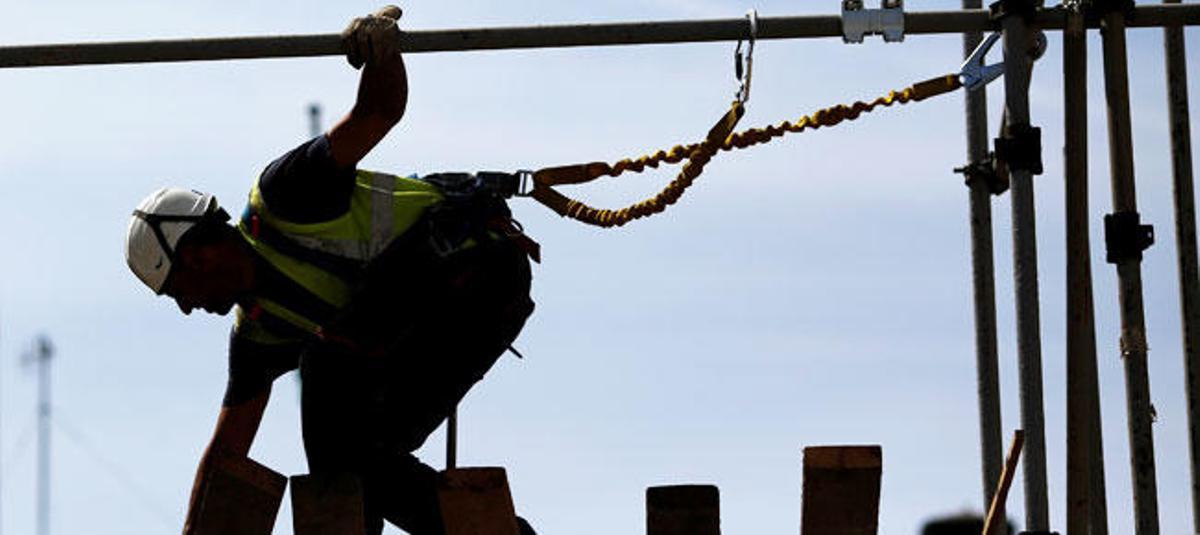 Un trabajador de la construcción sujeto con arnés.