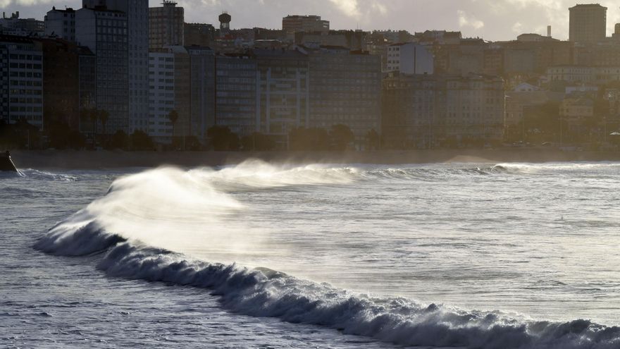 La alerta naranja en el litoral hace que las olas rebasen la duna de Riazor