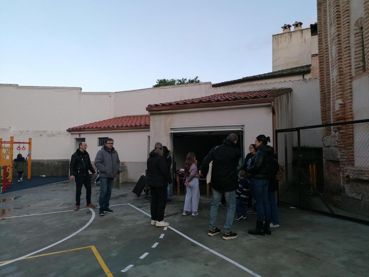 Padres reparten el chocolate en el patio del colegio