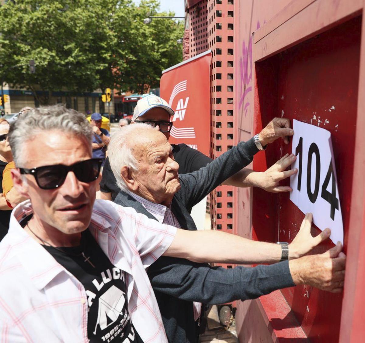 Faustino Suárez pone el cartel de 104 días con ayuda de Carlos Arias. | MARIO CANTELI