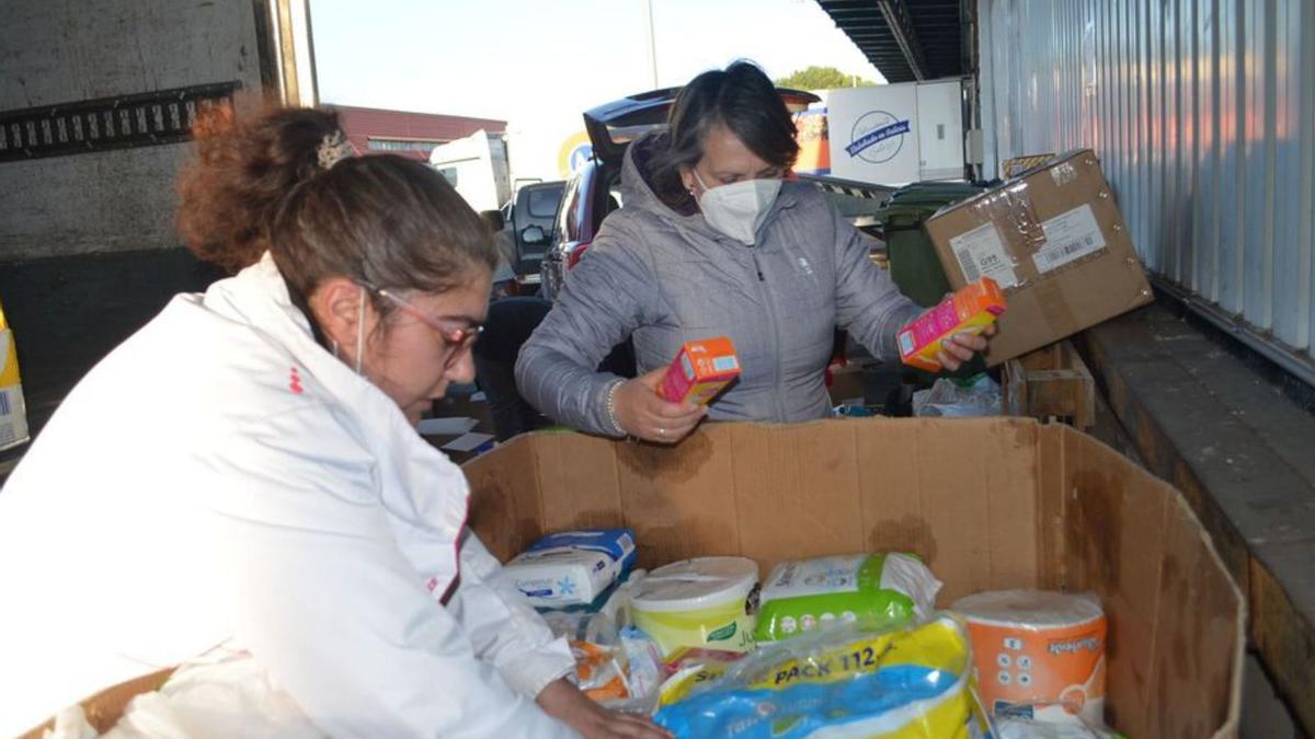 Dos mujeres organizan el material antes de subirlo al tráiler. | E. P.