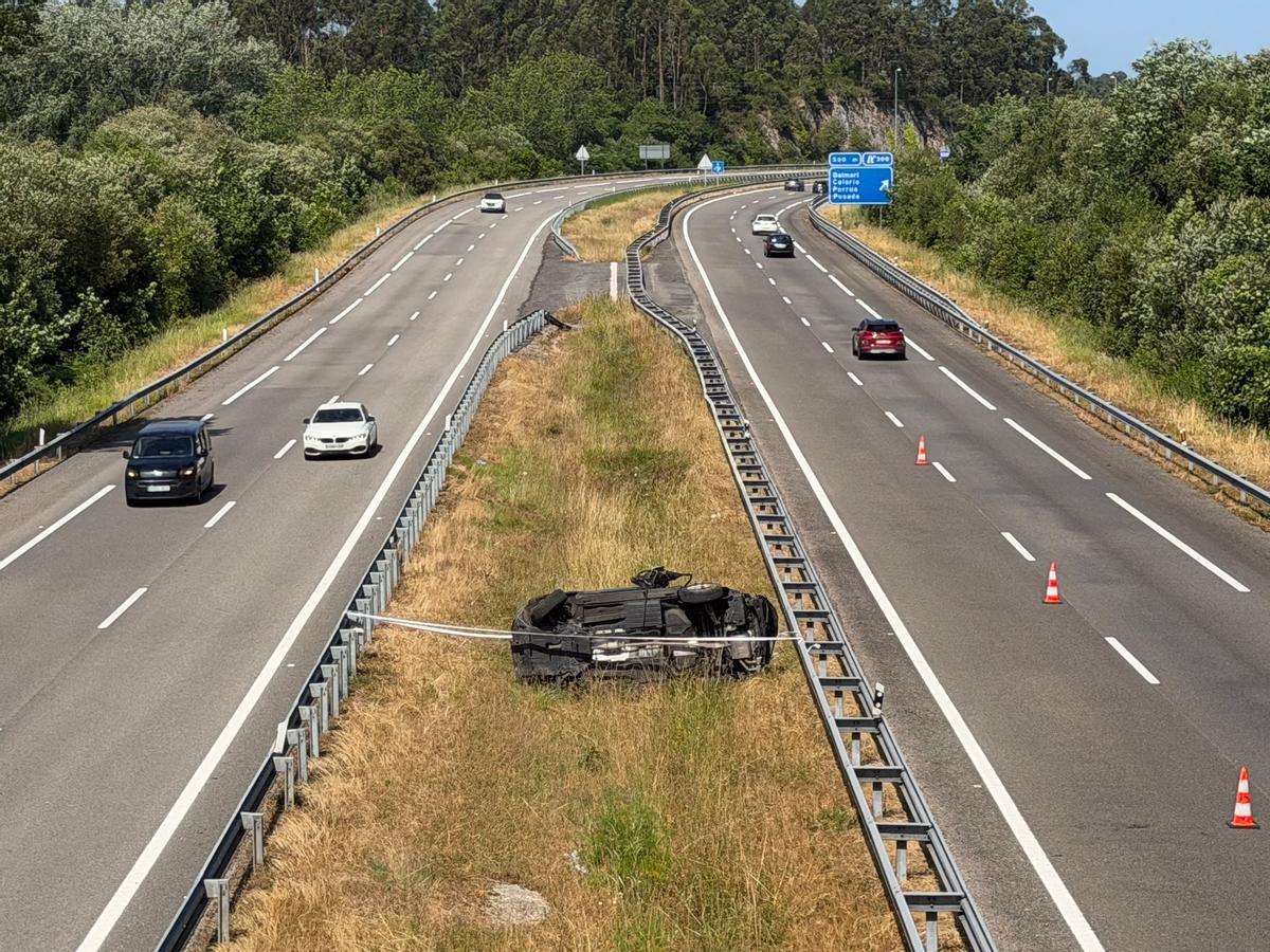 El coche volcado en la mediana